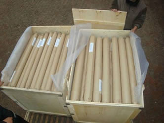 Two wooden boxes are filled with monel woven wire mesh rolls.