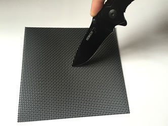 A dagger is stabbing a piece of crime safe mesh.
