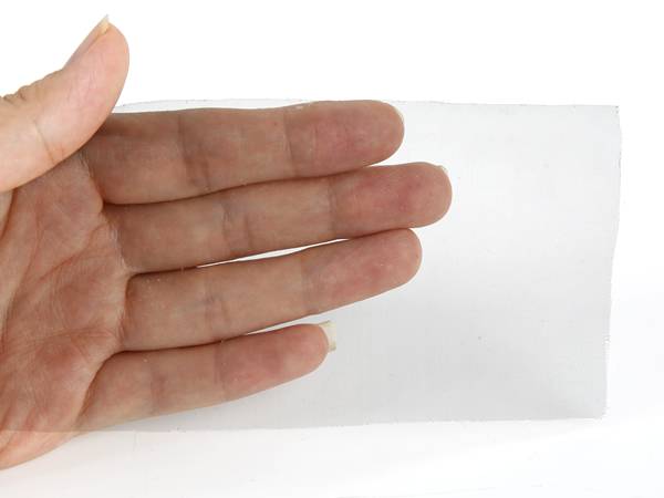 A hand is holding a piece of EMI shielding mesh.