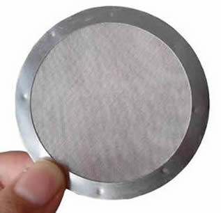 A hand is holding a piece of filter disc with spot welded edge.