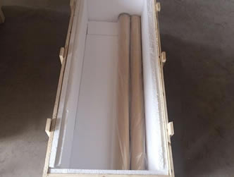 A wooden box with two rolls of inconel woven wire meshes in it.