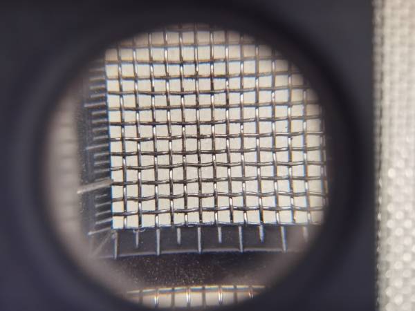 Measure the mesh count of Monel woven wire mesh with a magnifying glass gauge