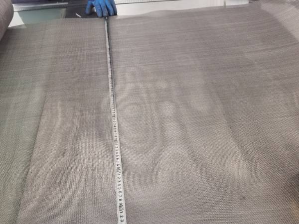 Measure the length of Monel woven wire mesh with a tape measure
