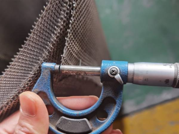 Measure Monel woven wire mesh wire diameter with a hand-held caliper