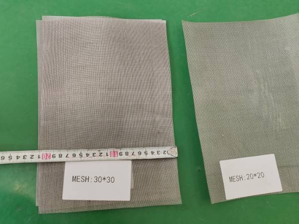 Measure nichrome woven wire mesh width with a tape measure on the green table