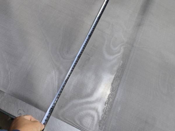 Measure titanium woven wire mesh size with a tape measure